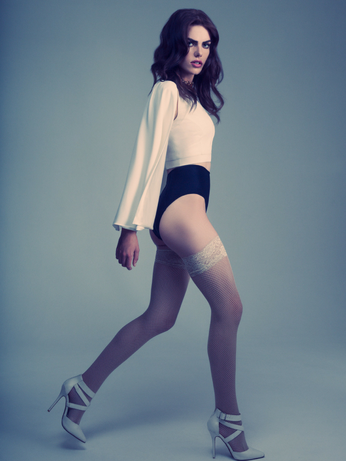 model wearing white long sleeved top and black shorts with white fishnet thigh highs