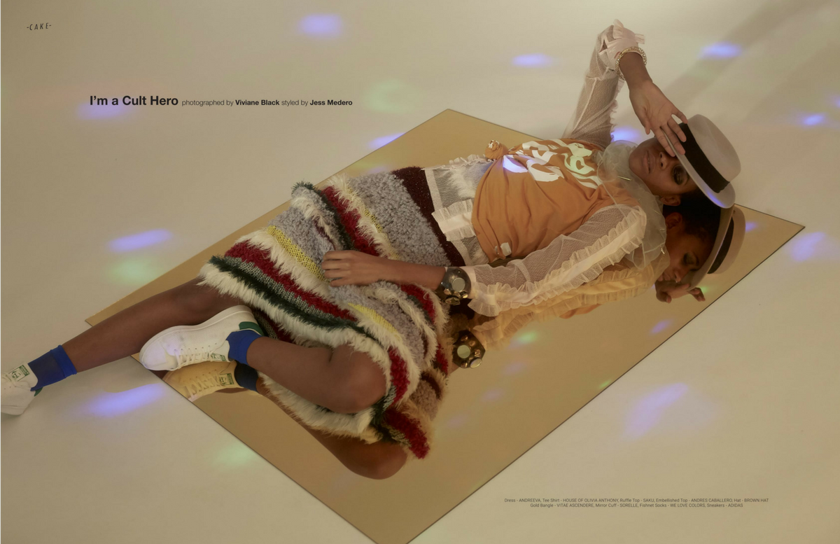 model laying on the floor wearing fuzzy skirt, tulle shirt, and hat