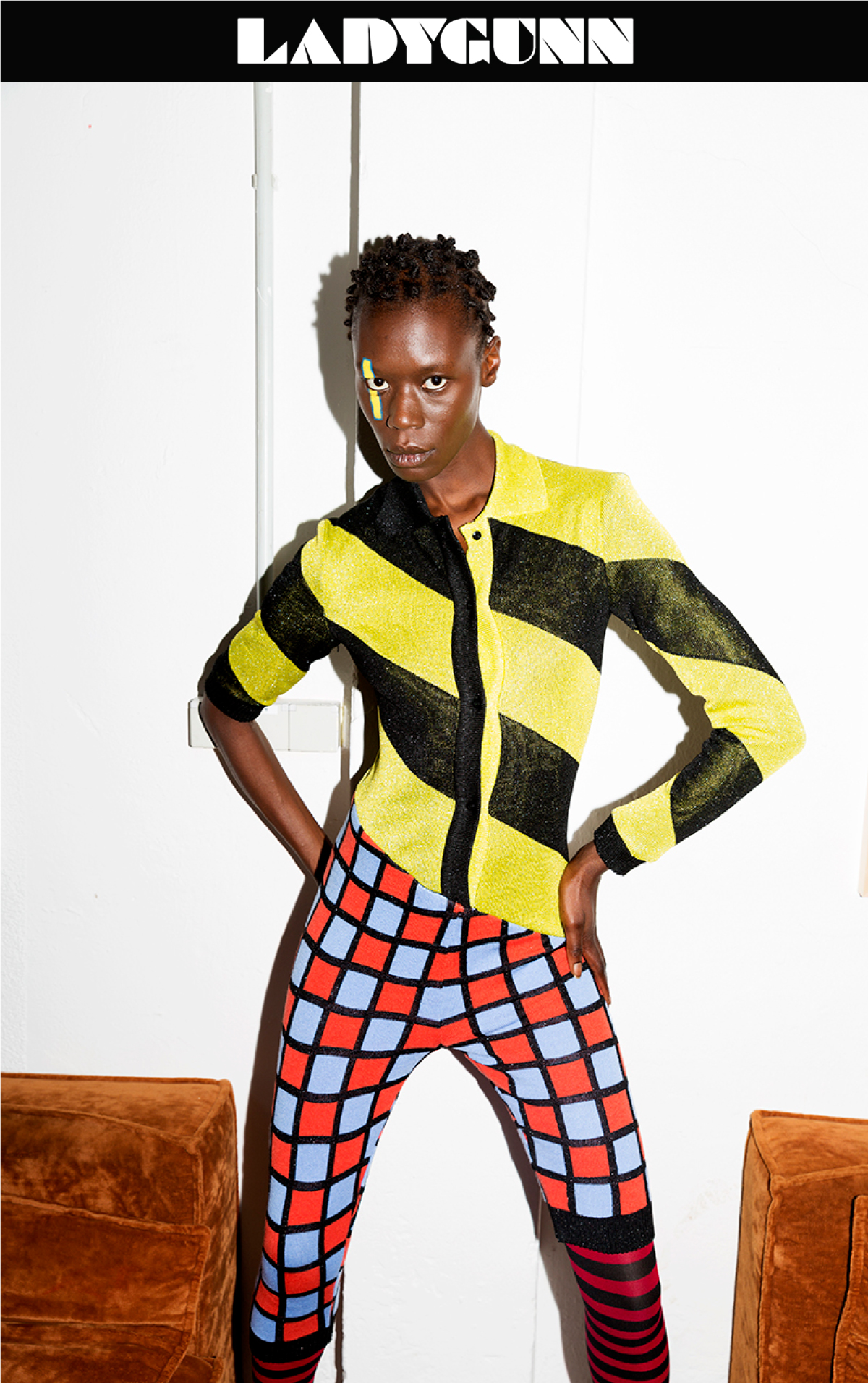 female model wearing neon patterned clothes stading on a white background