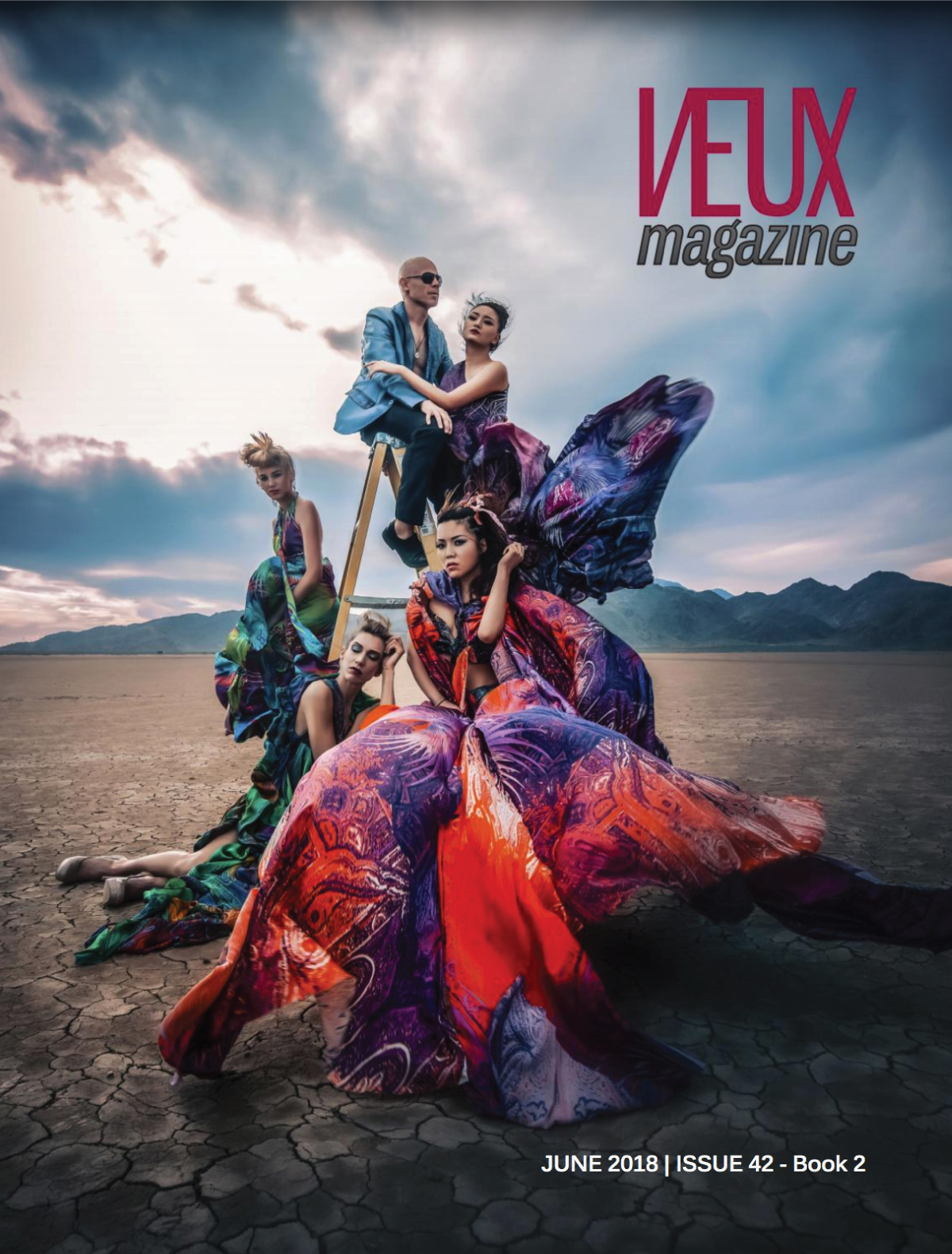 Veux Magazine Cover with four models in colorful big dresses posing in the dessert
